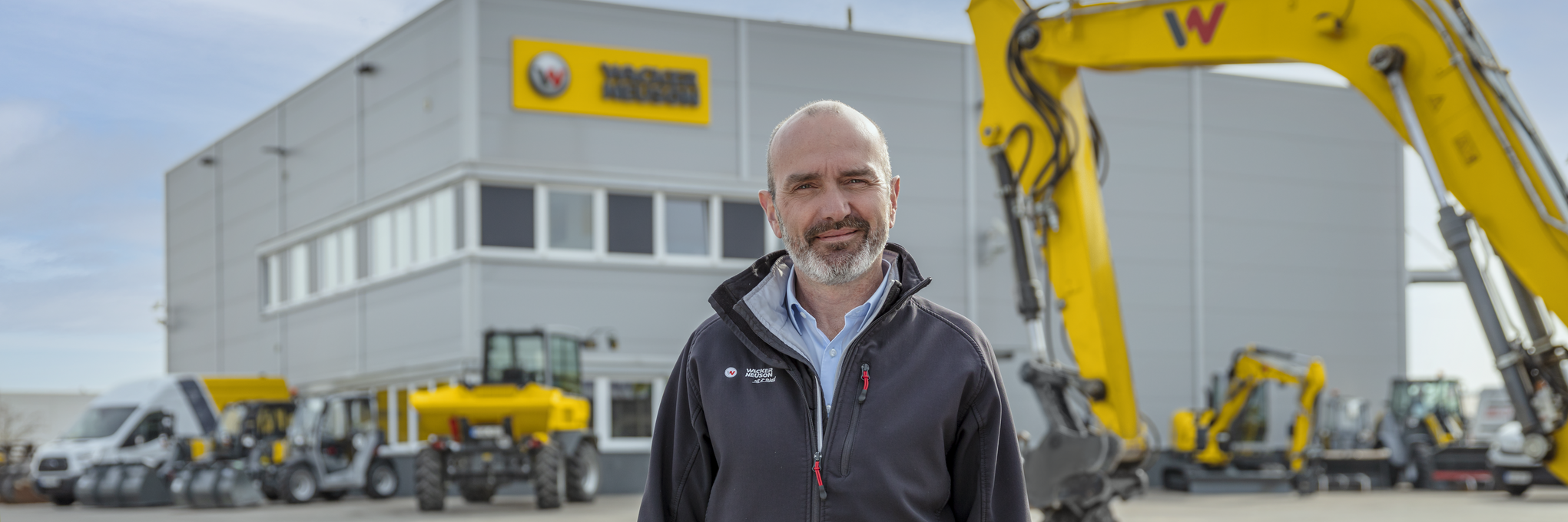 Wacker Neuson Mitarbeiter steht vor Wacker Neuson Mietstation.