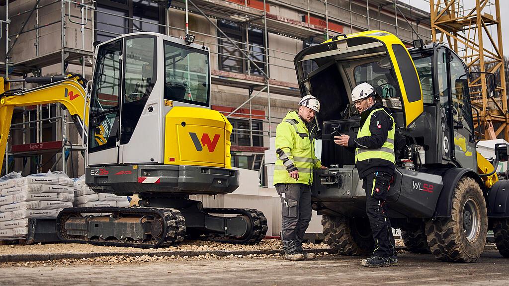 Zwei Kunden stehen vor Maschinen von Wacker Neuson