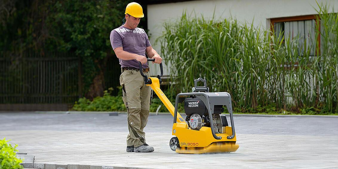 Wacker Neuson vibratory plate in action on paving stone 